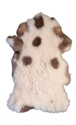 Un tapis peau de mouton blanc et brun sur un fond blanc.