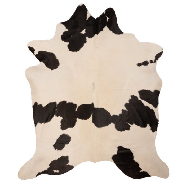Un tapis peau de vache moelleux noir et blanc sur fond blanc.