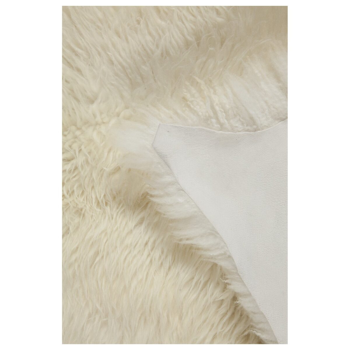 Un gros plan d'un Tapis peau de mouton blanc écru | Oreiller en fourrure 100×65 cm.