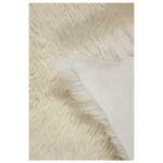 Un gros plan d'un Tapis peau de mouton blanc écru | Oreiller en fourrure 100×65 cm.