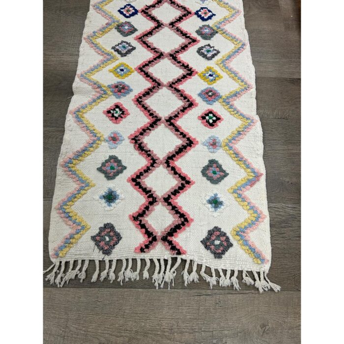 Un tapis principal vibrant Tapis berbère laine fait avec des franges au sol.