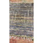 Un tapis Tapis berbère Beni Ouarain bleu et jaune avec des franges, mesurant 140x115cm.
