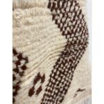 Un gros plan d'un Grand tapis marocain en laine marron et blanc mesurant 230x140 cm.