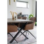 Un rectangulaire vintage de style Tapis avec quatre chaises en cuir marron.