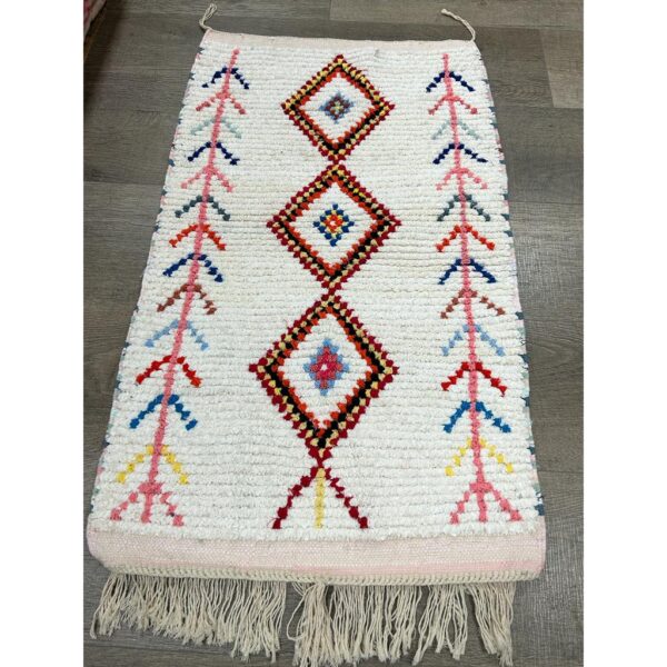 Un vibrant Tapis berbère écru avec des franges.