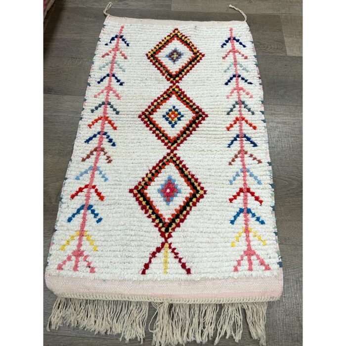 Un vibrant Tapis berbère écru avec des franges.