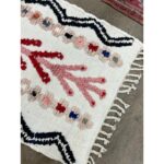 Un Tapis long berbère | Tapis 130x68 cm blanc et rose avec pompons et franges.