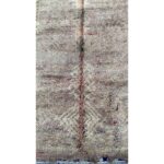 Un tapis Tapis berbère à poils longs beige et marron avec un motif dessus mesurant 315x160 cm.