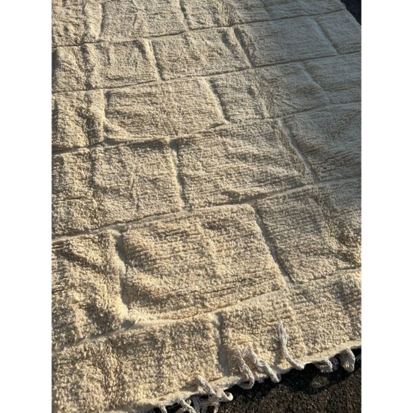 A Tapis Beni Ouarain blanc | 400x300 cm avec franges au sol.