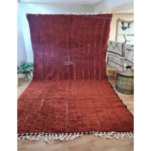 Un tapis marron chocolat poil long avec des franges sur le sol.