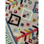 Un joli tapis berbère laine coloré | 114x70 cm rose avec des motifs colorés.