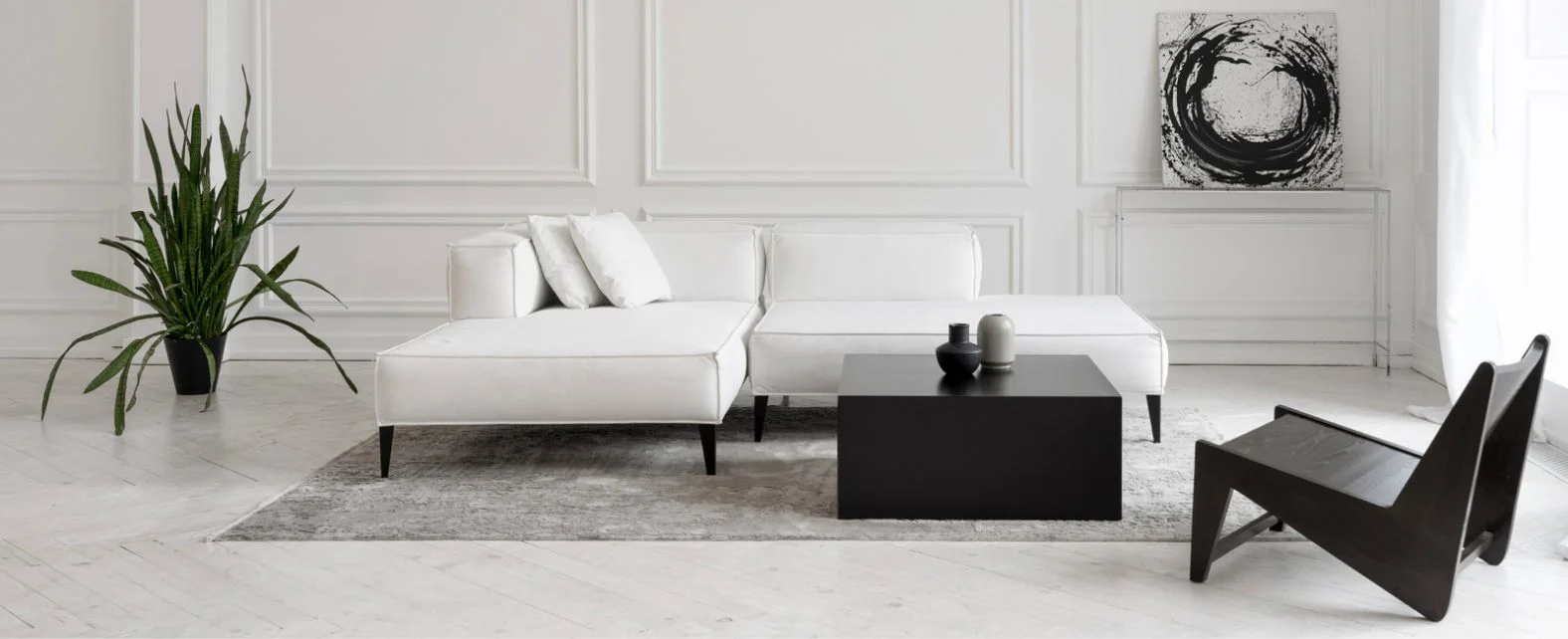 Salon minimaliste avec un canapé blanc et un tapis gris