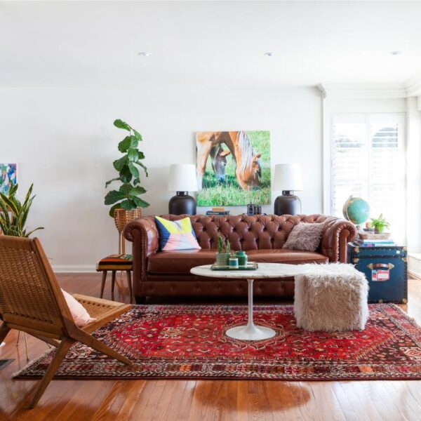 Tapis vintage rouge devant un canapé Chesterfield