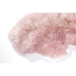 Un Tapis peau de mouton rose bonbon sur une surface blanche.