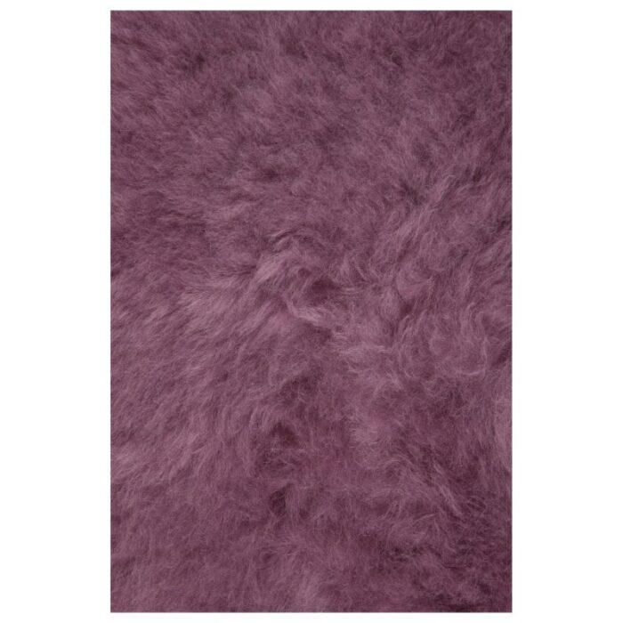 Un Tapis peau de mouton rose | 100×65 cm sur un fond blanc.