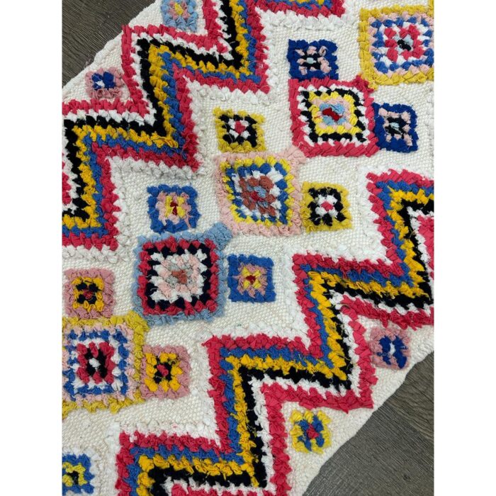 Un tapis berbère multicolore fait main de 114x60 cm avec un motif à chevrons.