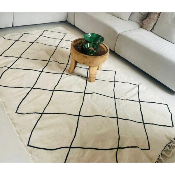 Un Tapis kilim ethnique | Tapis de 245x145 cm avec un motif noir et blanc dessus.