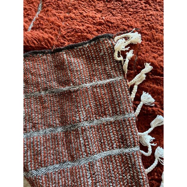 Un Tapis marron chocolat poil long avec des pompons dessus, mesurant 250x150 cm.