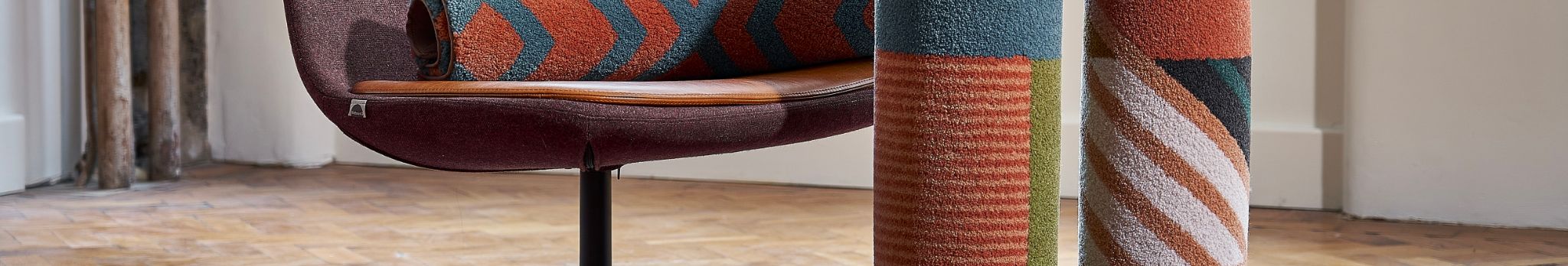 Qui sommes-nous : Une chaise surmontée d'un tapis coloré.