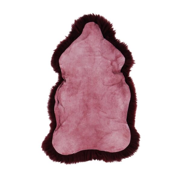 Un Tapis peau de mouton rouge merlot sur fond blanc.