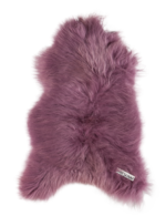 Un Tapis peau de mouton rose foncé | 100×65 cm sur un fond noir.