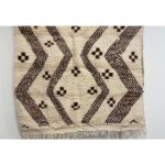Un grand tapis marocain en laine | 230x140 cm en beige et marron, présentant un motif géométrique.