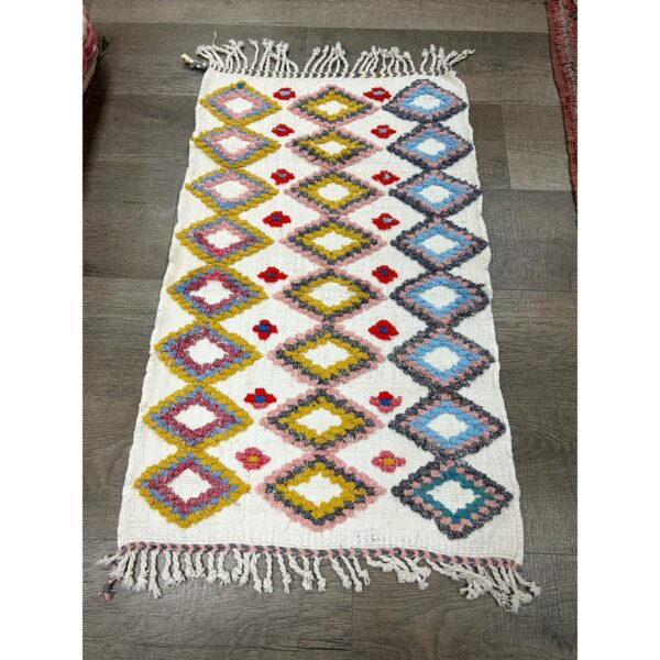 Un vibrant Tapis berbère en laine cousu à la main | 108x67 cm avec franges au sol.