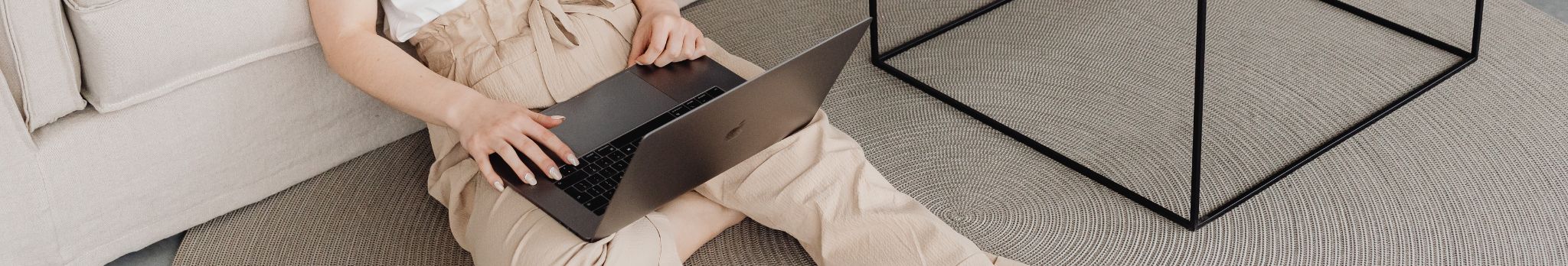Une femme assise par terre avec un ordinateur portable, Contactez-nous.