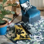 Une chaise bleue avec des oreillers sur un tapis.