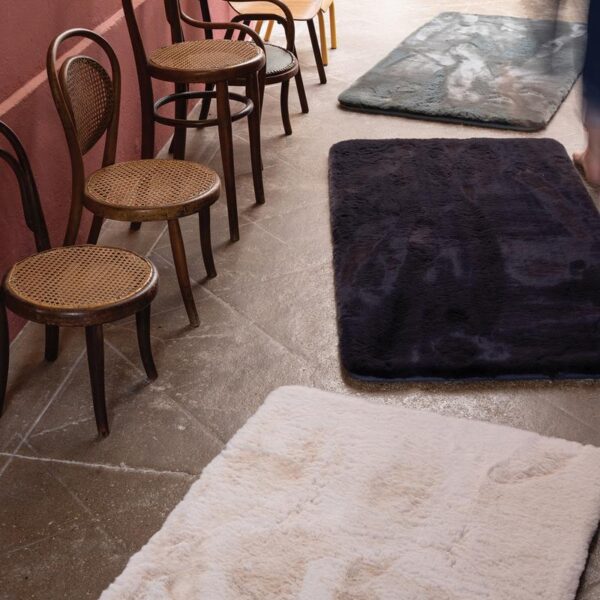 Une collection de tapis sur le sol d’une pièce.