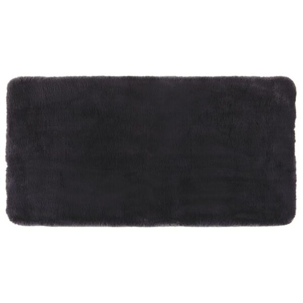 Un tapis en fourrure noire sur fond blanc.