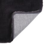 Un tapis en fourrure noire avec un support gris.