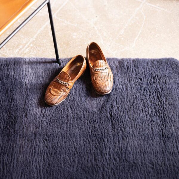 Une paire de chaussures marron sur un tapis bleu.