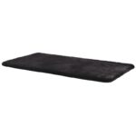 Un tapis en fourrure noire sur fond blanc.