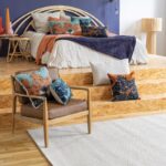 Une chambre bleue et orange avec du parquet et un lit.