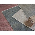 Un ensemble de trois tapis avec une chaise en bois.