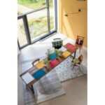 Une pièce avec une table et des chaises colorées.