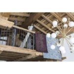 Un lustre suspendu à une balustrade en bois dans une pièce