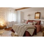 Un lit dans une chambre aux murs blancs.