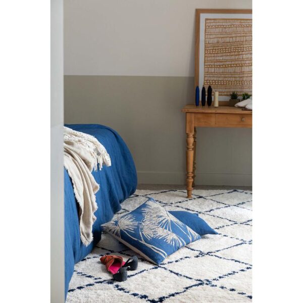 Une chambre bleue avec un lit et un tapis.