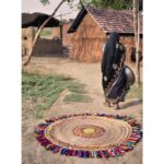 Une femme en sari passe devant un tapis.
