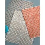 Trois tapis au design géométrique sont inclus.