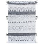 Un tapis tribal blanc et noir avec des franges.