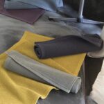 Un ensemble de serviettes sur une table à côté d'un lit.