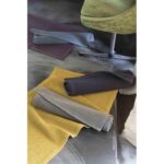 Un ensemble de serviettes sur une table à côté d'une chaise avec un ruban à mesurer en cm.