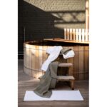 Un bain à remous en bois avec des serviettes dessus.