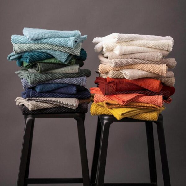 Une pile de serviettes pliées sur un tabouret.