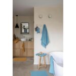 Une salle de bain avec des serviettes bleues et une baignoire.