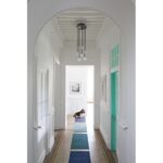 Un couloir avec une arcade et un chien sur un tapis.