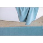 Un tapis de bain bleu avec une serviette dessus.